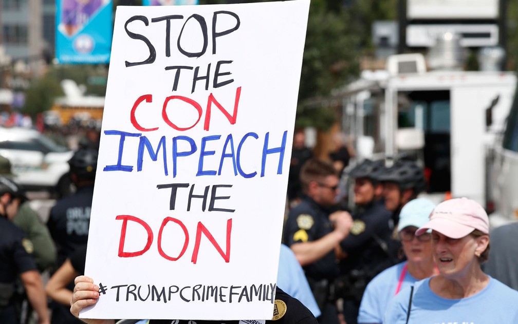 Cartaz exibido por manifestante em Orlando, na Flórida, pede impeachment do presidente, no dia do lançamento da campanha de reeleição de Donald Trump, na terça-feira (18) — Foto: Gregg Newton/AFP