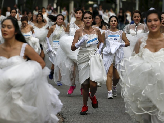 Centenas de noivas e noivos participaram neste sábado (28) de uma corrida temática em Bangcoc, na Tailândia, na qual os casais perto de se casarem precisam correr vestidos com as roupas da festa de casamento e tênis de corrida (Foto: Athit Perawongmetha/Reuters)