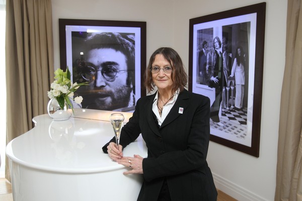 A irmã mais nova do músico John Lennon (1940-1980), Juliet Baird, em em frente a fotos do irmão (Foto: Getty Images)