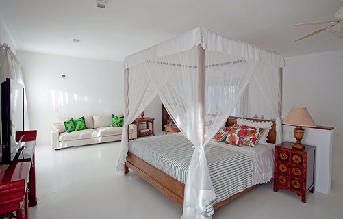O estilo de casa de praia está presente nos tons neutros e na cama com dossel do quarto projetado pela arquiteta Ligia Resstom, em Trancoso. Há alguns toques de cor nas almofadas