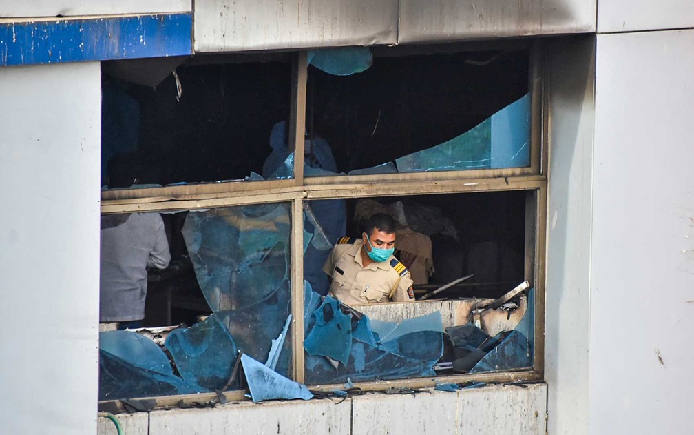 Policial inspeciona sala queimada no Hospital Vijay Vallabh — Foto: Vinamra Acharekar / AFP Photo