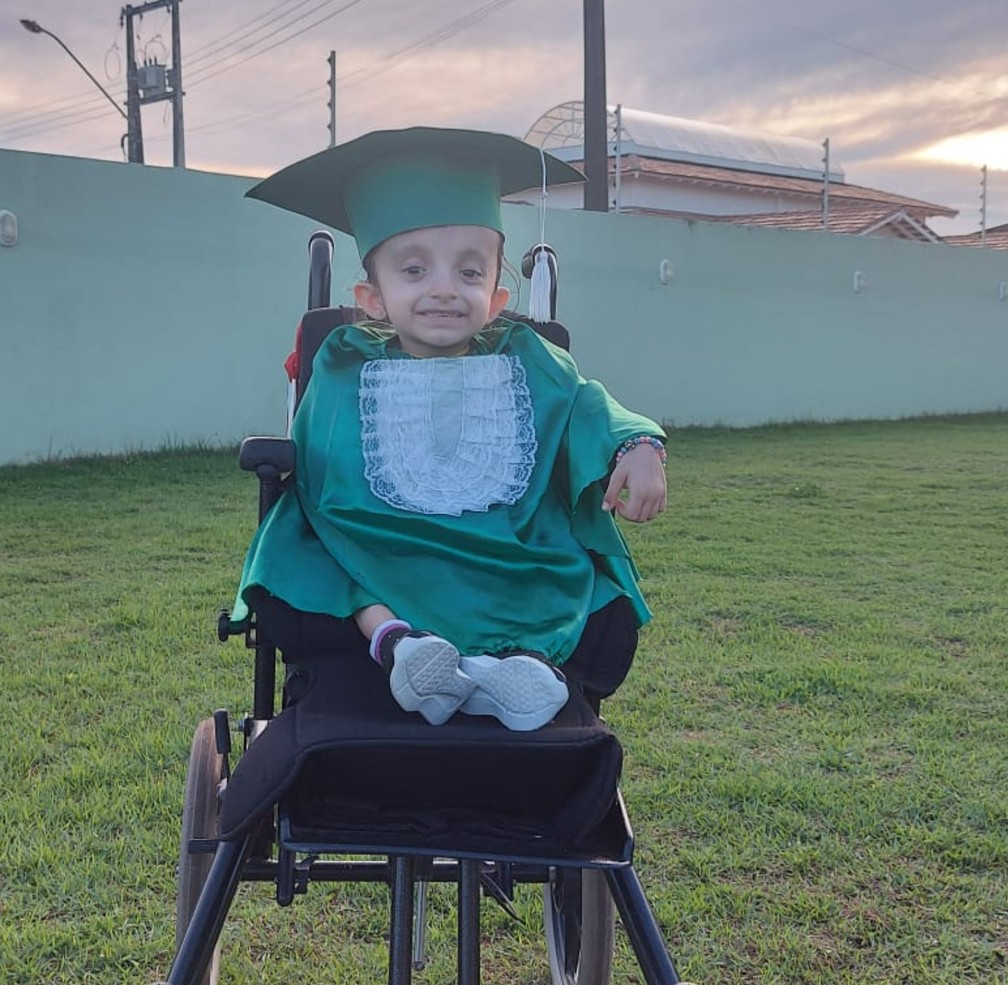 Helena, menina dos "ossos de vidro", com a beca de formatura — Foto: Arquivo Pessoal/Kelly Renata