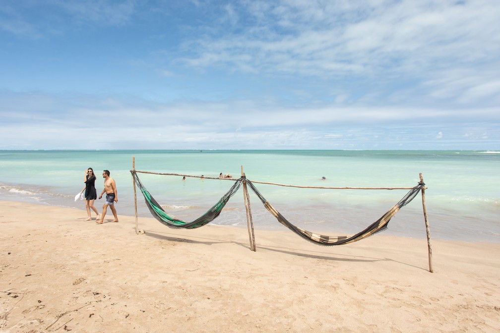 Redes para descanso e mar "caribenho" ao fundo: paisagem da Praia de Lages, destaque na Rota dos Milagres — Foto: Celso Tavares/G1