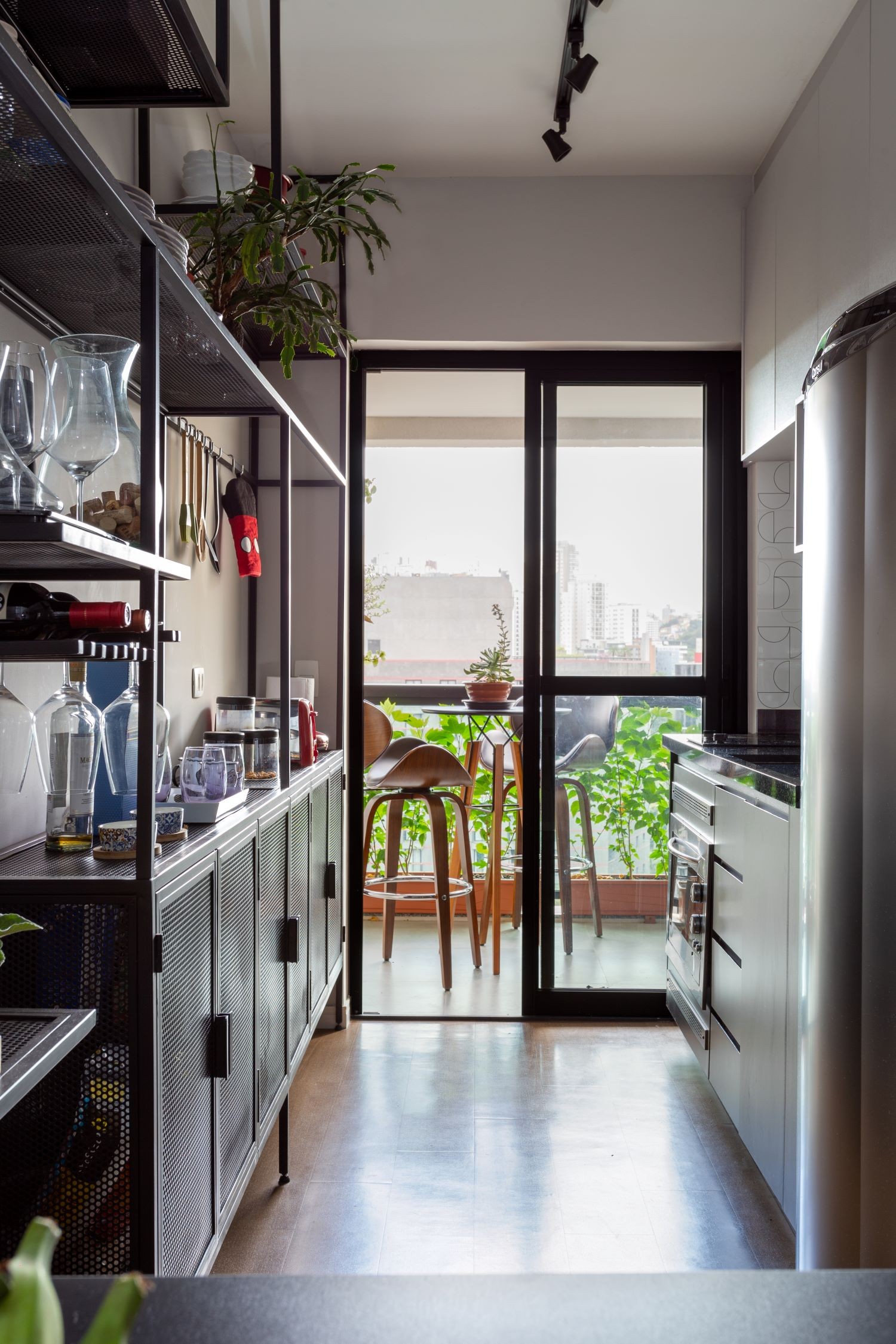 COZINHA / CORREDOR | Com a nova divisão de espaços, a cozinha foi levada para perto da varanda. Luminárias são da Yamamura (Foto: Divulgação / Leila Viegas)