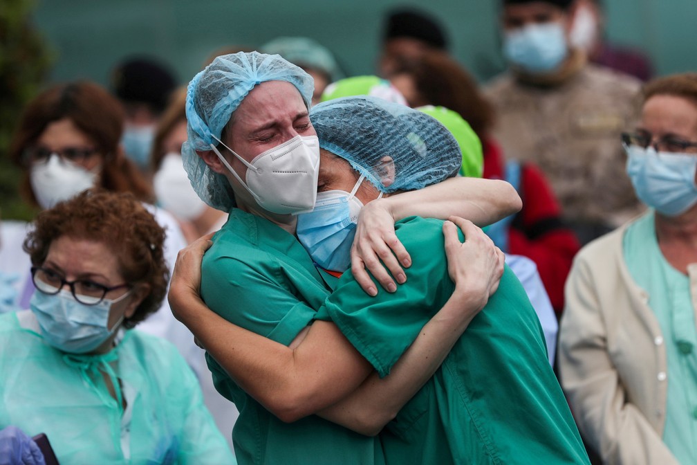 13 de abril - Profissionais de saúde usando máscaras de proteção choram durante uma homenagem a seu colega de trabalho Esteban, um enfermeiro que morreu de complicações relacionadas à Covid-19 durante a pandemia em Leganes, na Espanha. Mais de 46 mil pessoas morreram vítimas da doença no país — Foto: Susana Vera/Reuters