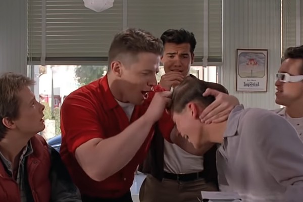 Michael J. Fox como Marty McFly observando o pai dele ser vítima de bullying de Biff Tannen (Foto: Reprodução)