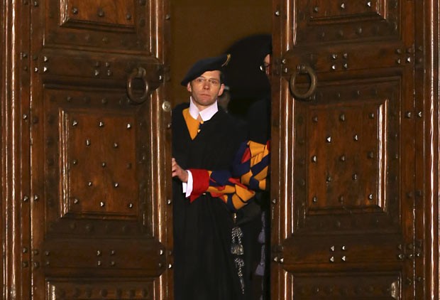 Membro da Guarda Suíça fecha as portas da residência papal de verão, em Castel Gandolfo, para marcar o fim do pontificado de Bento XVI, nesta quinta-feira (28) (Foto: AP)