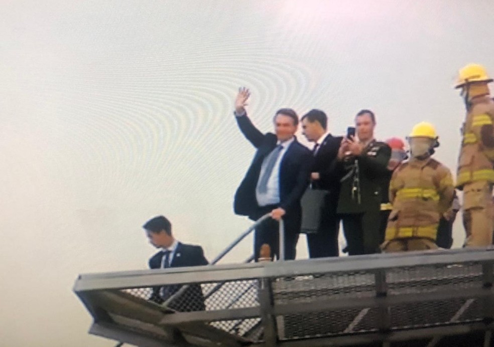 Bolsonaro acena para fieis de igreja ao sair de helicóptero  — Foto: Misael Brito/GloboNews