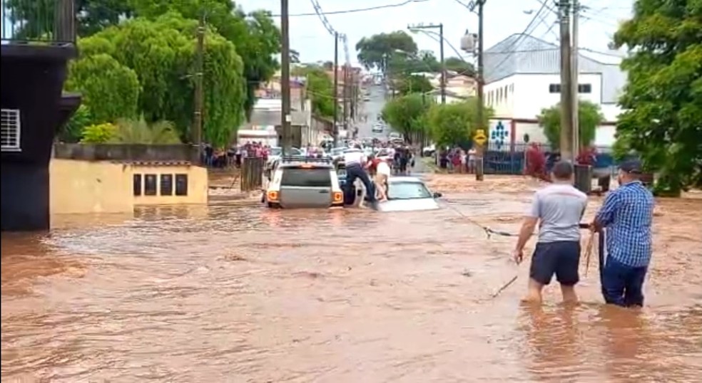 Família resgatada após ficar com carro preso em correnteza provocada por estouro de barragem em Pardinho — Foto: Mayla Rodrigues/TV TEM
