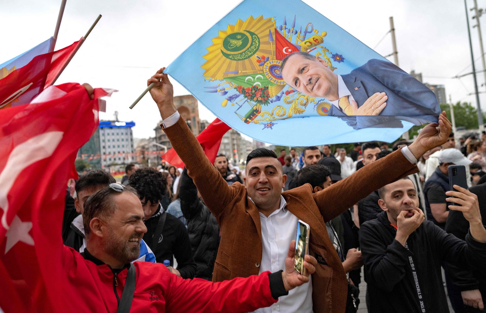 Apoiadores do presidente turco Recep Tayyip Erdogan comemoram perto da Mesquita Taksim, na Praça Taksim, em Istambul, no dia do segundo turno presidencial. — Foto: Yasin AKGUL / AFP