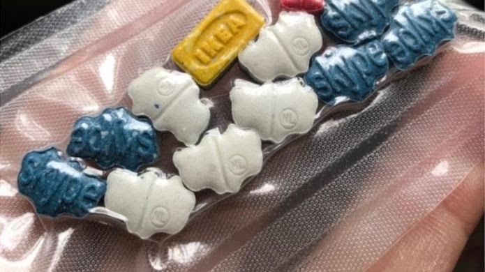 Imagem usada pela polícia para identificar o traficante: mão segura embalagem com pílulas de ecstasy (Foto: SOUTH WALES POLICE)
