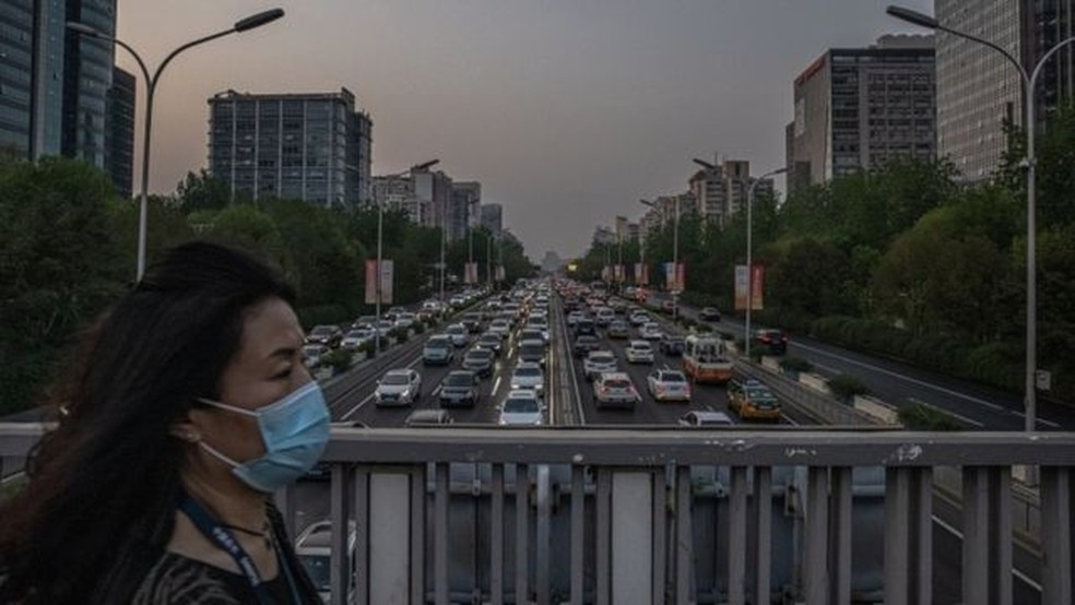 Pedestre em Pequim; China tem alcançado suas metas de controle de emissões, mas sofre pressão para adotar objetivos mais ambiciosos — Foto: EPA/ROMAN PILIPEY
