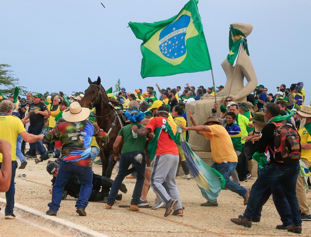 Policial montado é derrubado de seu cavalo diante da estátua da Justiça na Praça dos Três Poderes, em Brasília — Foto: Sergio Lima/AFP