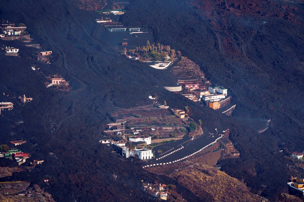 Lava ao redor de casas após erupção de vulcão no parque nacional Cumbre Vieja em El Paso, na ilha de La Palma, em 23 de setembro de 2021 na Espanha — Foto: Ramon de la Rocha/Pool via Reuters