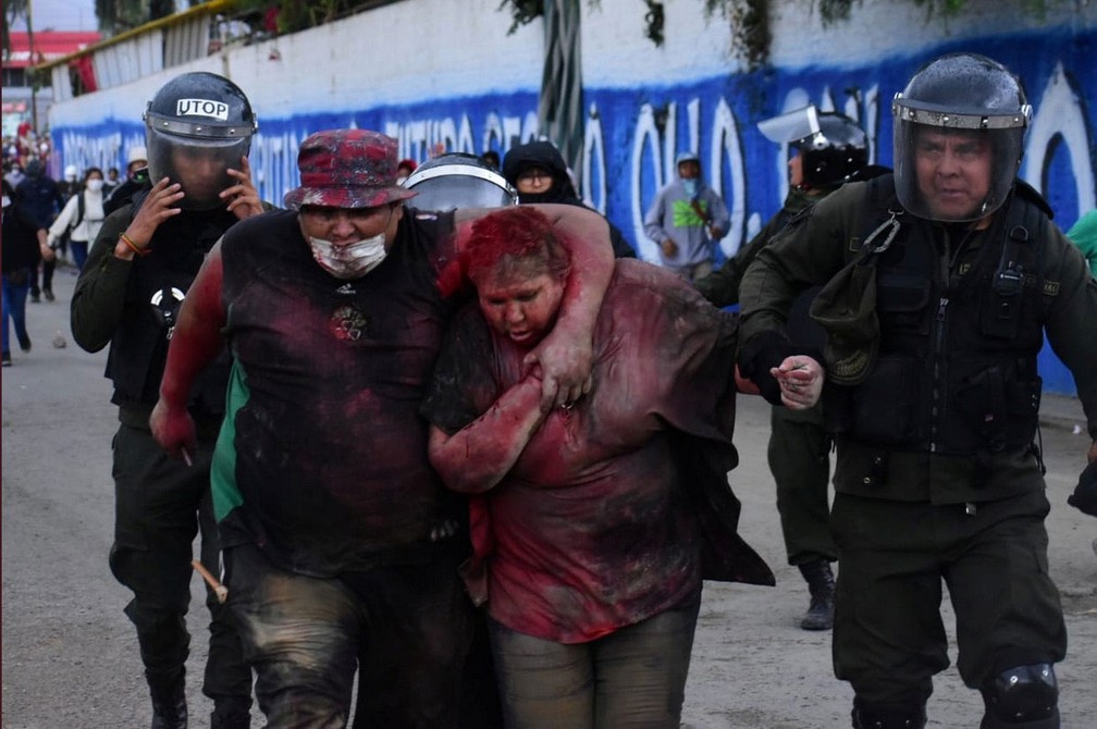 Patricia Arce, prefeita de Vinto, é resgatada por policiais; manifestantes incendiaram a prefeitura, jogaram tinta vermelha em Arce e cortaram seus cabelos — Foto: Daniel James/Los Tiempos Bolivia/via Reuters