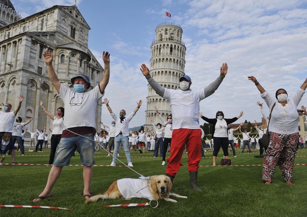 PISA, ITALY - MAY 30:  People wearing face masks while keeping social distances and a dog take part in a flash mob near the tower of Pisa on May 30, 2020 in Pisa, Italy. The city of Pisa in Piazza dei Miracoli celebrated the reopening of the Tower of Pisa (Foto: Getty Images)