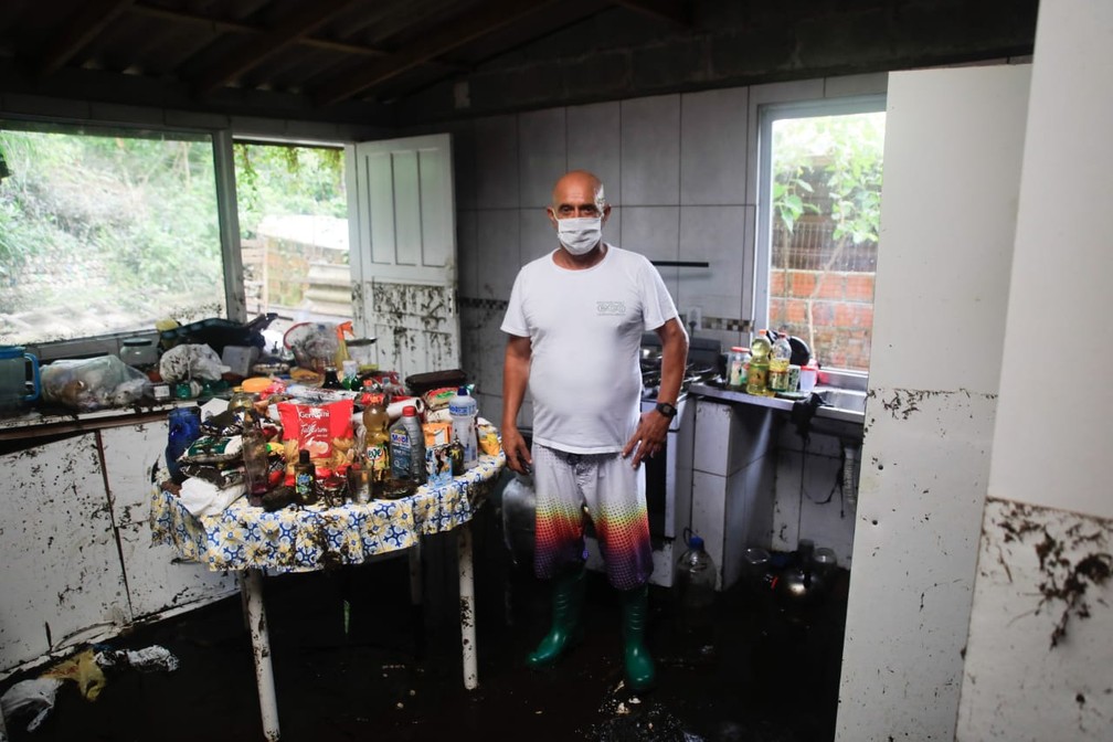 Roberto Carlos Vicente, morador que teve casa atingida por enxurrada em Florianópolis contabiliza estragos nesta terça-feira (26) — Foto: Diogenes Pandini/NSC