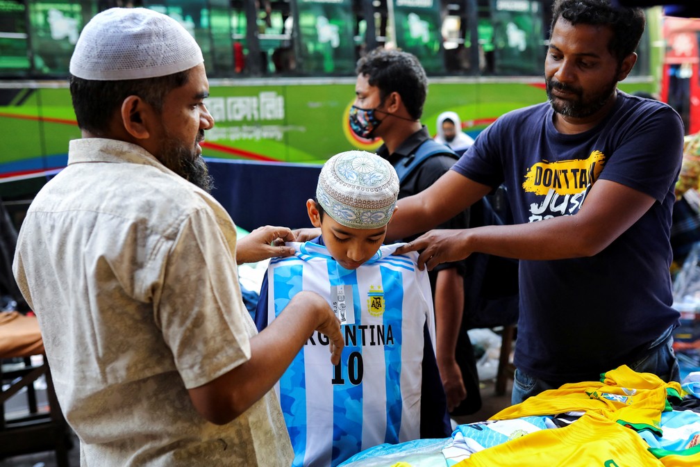 Jovem torcedor experimenta camisa da Argentina numa rua de Dhaka, capital de Bangladesh — Foto: Mohammad Ponir Hossain/Reuters