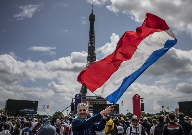 PARIS, FRANCE - AUGUST 08: A man waves the French flag as spectators attend the Olympic Games handover ceremony on August 8, 2021 in Paris, France. On August 8, during the closing ceremony of the Tokyo Olympics, Anne Hidalgo, mayor of Paris, will official (Foto: Getty Images)