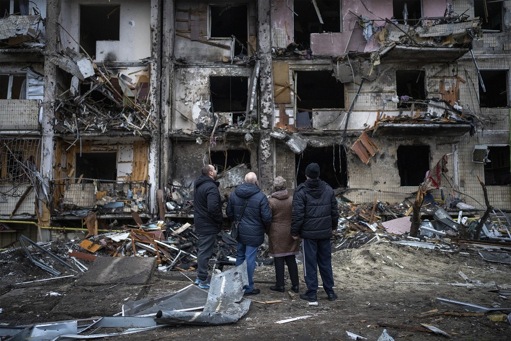25 de fevereiro - Pessoas observam os danos após ataque na cidade de Kiev, Ucrânia — Foto: Emilio Morenatti/AP