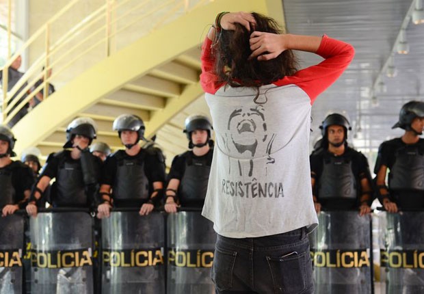 Estudante olha para policiais da Tropa de Choque da PM em ocupação do Centro Paula Souza (Foto: Rovena Rosa/Agência Brasil)