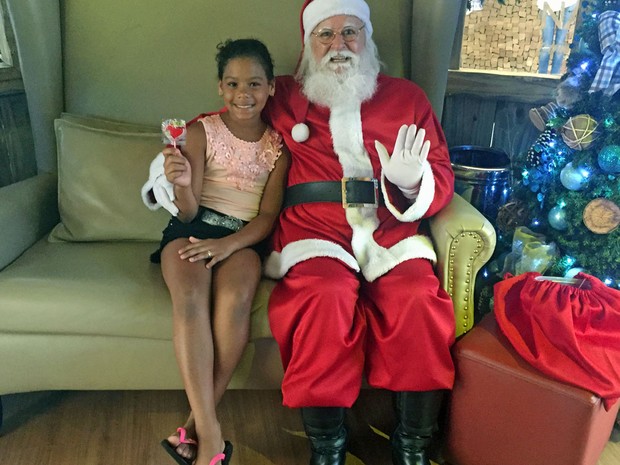 Papai Noel entrega guloseima para criança em shopping da Asa Norte, em Brasília (Foto: Jéssica Nascimento/G1)