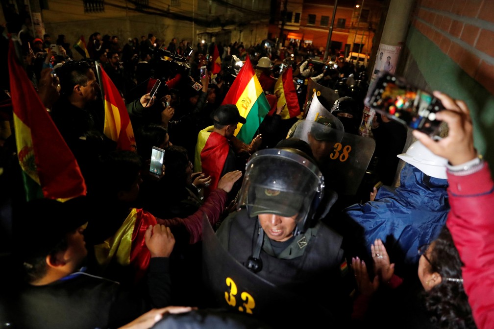 Manifestantes cumprimentam policial em La Paz durante protesto contra reeleição de Evo Morales nesta sexta-feira (8) — Foto: Carlos Garcia Rawlins/Reuters
