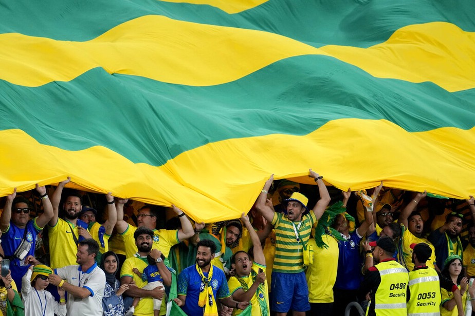 Torcedores da seleção brasileira estendem bandeirão, na Copa do Mundo do Catar