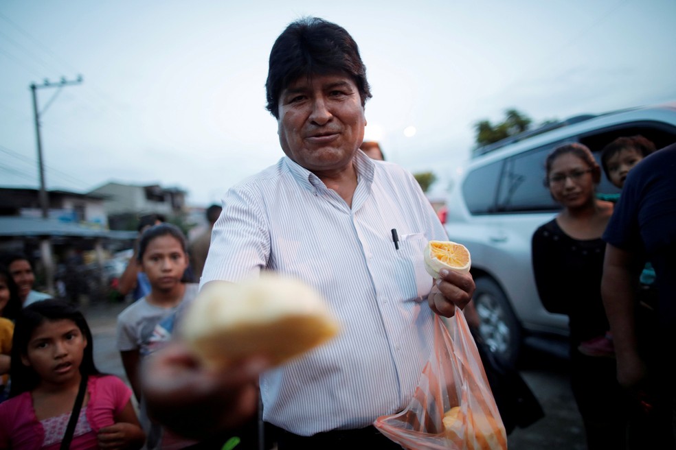 19 de outubro - O então presidente Evo Morales oferece frutas aos moradores em uma rua de Shinahota, na região de Chapare, na Bolívia. Morales renunciou à presidência após denúncias de fraude na última eleição e de uma escalada nas tensões no país — Foto: Ueslei Marcelino/Reuters