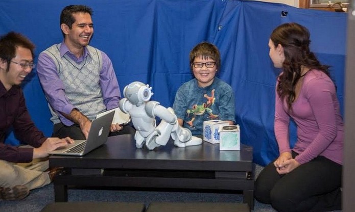Sessão de terapia do robô NAO com criança com autismo (Foto: Divulgação/DU)