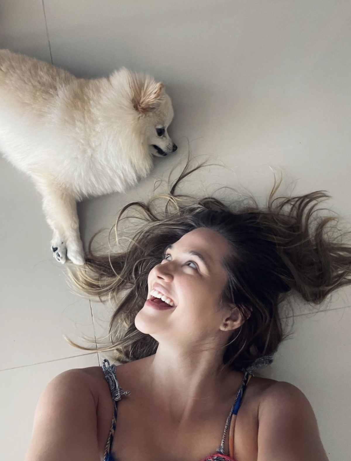 Na foto, a atriz Juliana Paiva deitada ao lado do seu cachorro Sancho da raça lulu-da-pomerânia (Foto: Instagram/ @juulianapaiva/ Reprodução)