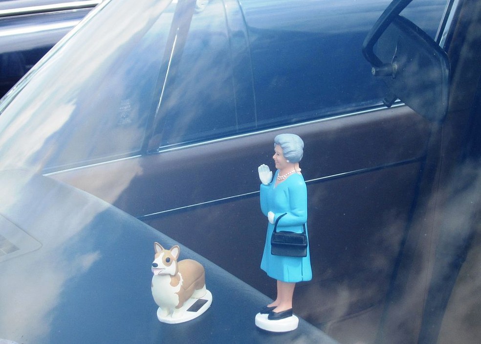 Elizabeth II e um de seus corgis: adorno de carro mostra que os cães se tornaram uma marca registrada da realeza (Foto: https://commons.wikimedia.org/wiki/File:Jaguar_XJ_3.4_containing_Queen_n_%27Corgi_dashboard_ornament._The_ornament.JPG)