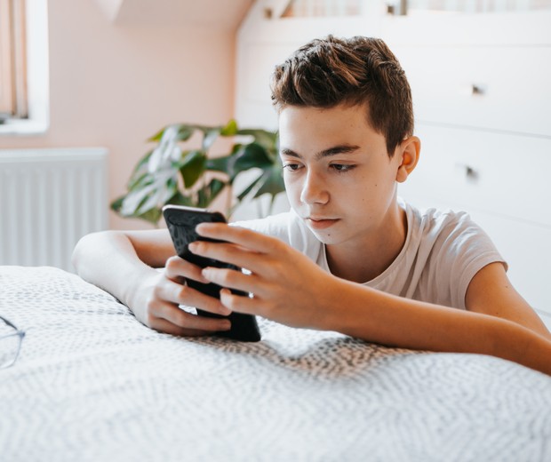 Menino adolescente mexendo no celular (Foto: Carol Yepes/Getty Images)