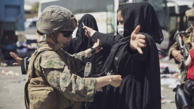Mulher afegã passa por controle dos EUA para entrar no aeroporto de Cabul; tropas americanas estavam em alerta máximo após atentado ocorrido no dia 26 (Foto: REUTERS via BBC)