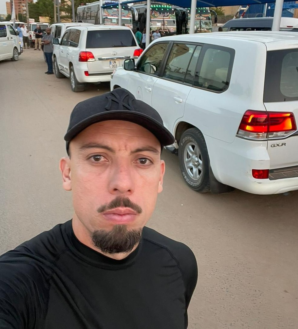 Paulo Sérgio do lado da fila de carros que levam os estrangeiros até o aeroporto em Cartum, capital do Sudão — Foto: Arquivo pessoal/ Paulo Sérgio