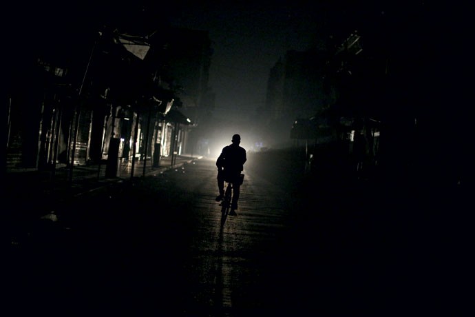 No escuro: ciclista pedala em rua sem iluminação na cidade de Douma, na região metropolitana de Damasco (Foto: AFP Photo/ ABD Doumany)