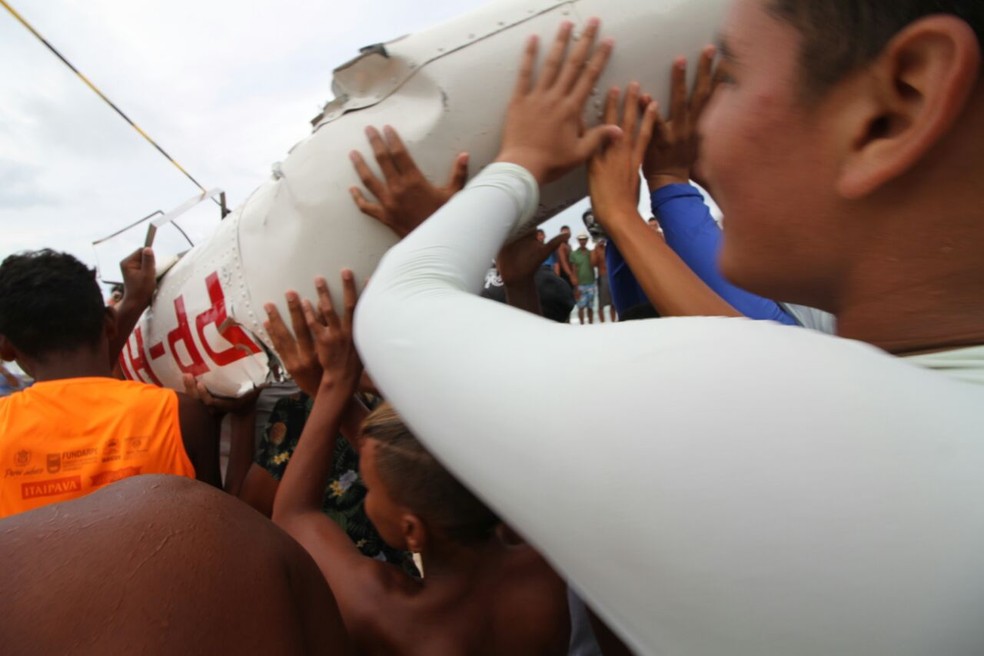 População ajuda a carregar parte da fuselagem do Globocop que caiu no Recife, nesta terça (23) (Foto: Aldo Carneiro/Pernambuco Press)