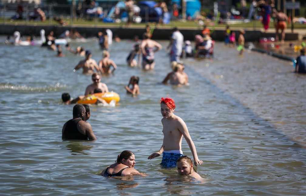 Pessoas tentam se refrescar do calor em Chestermere, na província de Alberta, na terça-feira (29), no Canadá — Foto: Jeff McIntosh/The Canadian Press via AP