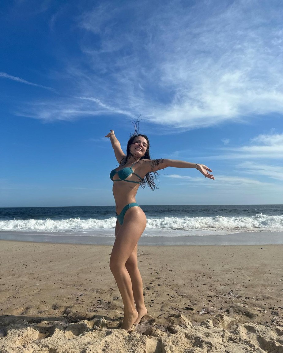 Larissa Manoela posa em praia com biquíni azul e celebra