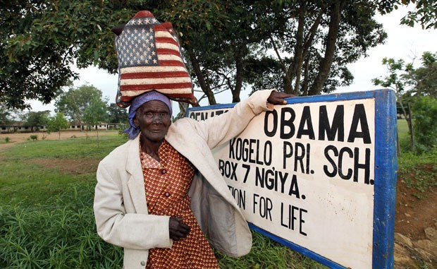 Rosa Anyango volta do mercado com uma sacola com a bandeira dos EUa e posa diante da escola Senador Barack Obama no Quênia (Foto: Thomas Mukoya/Reuters)