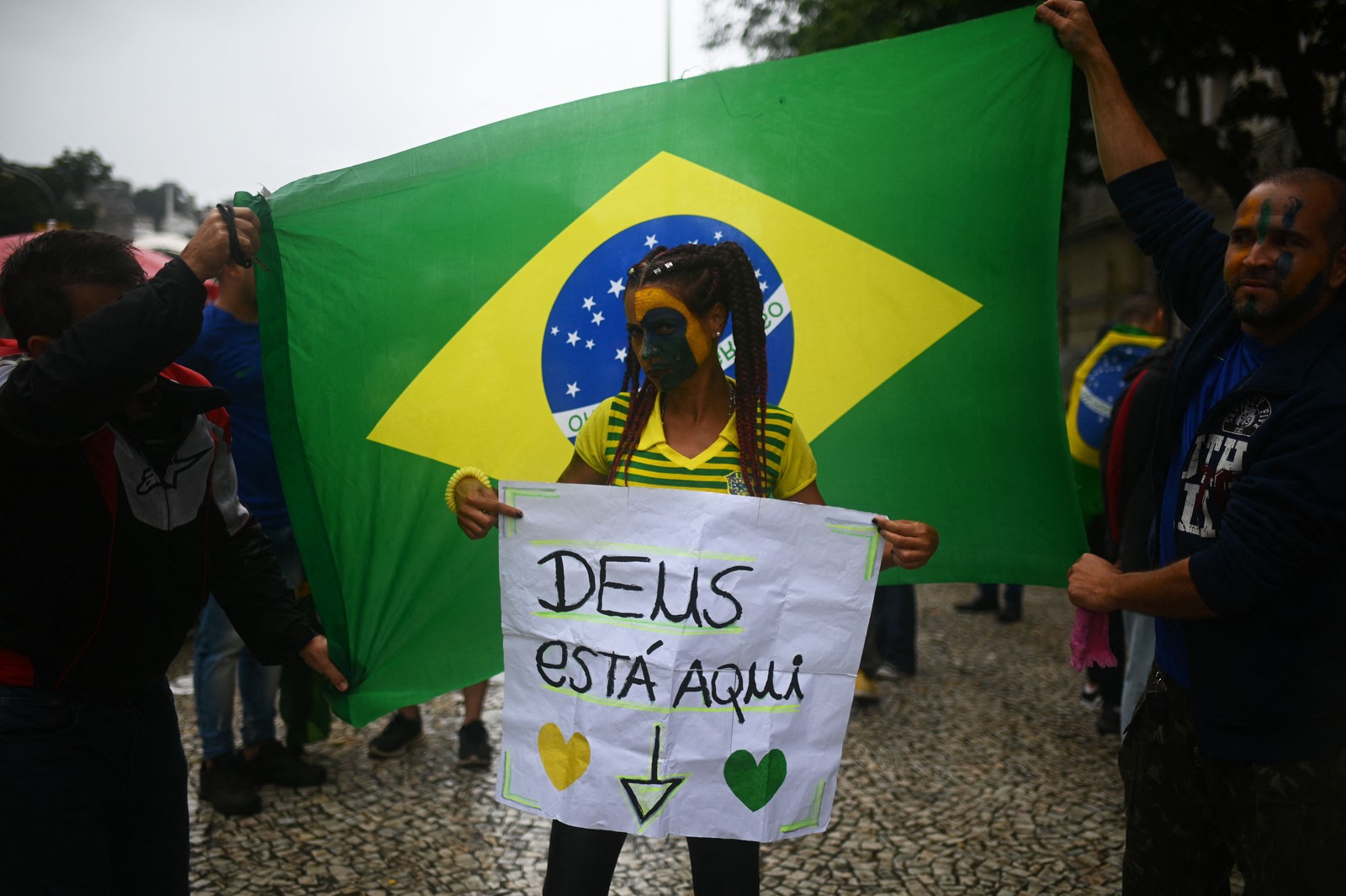 Apoiadora do presidente exibe cartaz que diz "Deus está aqui" — Foto: André Borges / AFP