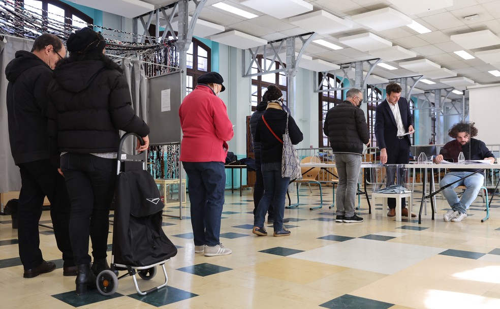 Eleitores franceses aguardam em fila para votar no primeiro turno das eleições presidenciais em Paris, no dia 10 de abril de 2022 — Foto: Thomas Samson/AFP