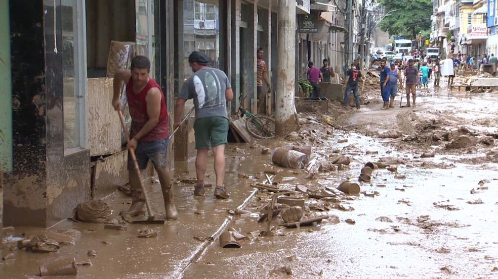 Moradores tentam fazer a limpeza da cidade de Iconha nesta segunda-feira, 20 de janeiro de 2020 — Foto: Reprodução/TV Gazeta