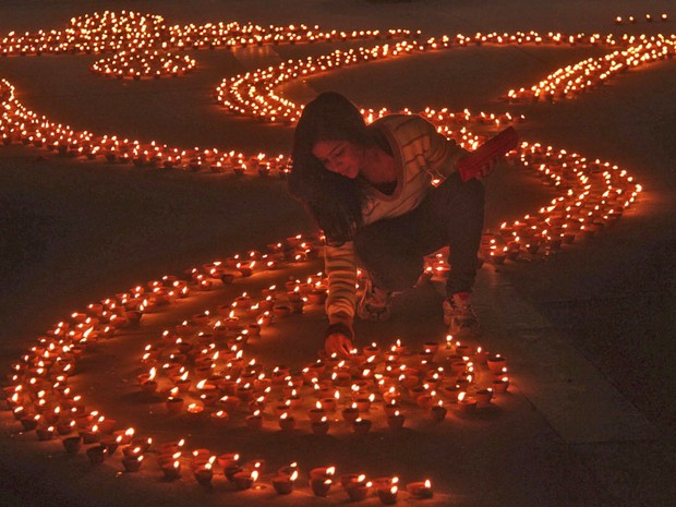 Garota acende vela na véspera do Diwali, o festival hindu das luzes, na cidade indiana de Chandigarh. (Foto: Ajay Verma/Reuters)