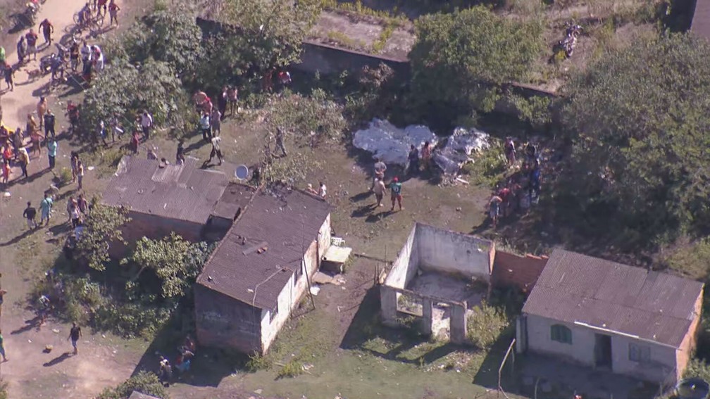 Moradores recolhem corpos no Complexo do Salgueiro, em São Gonçalo, após operação da PM — Foto: Reprodução/ TV Globo