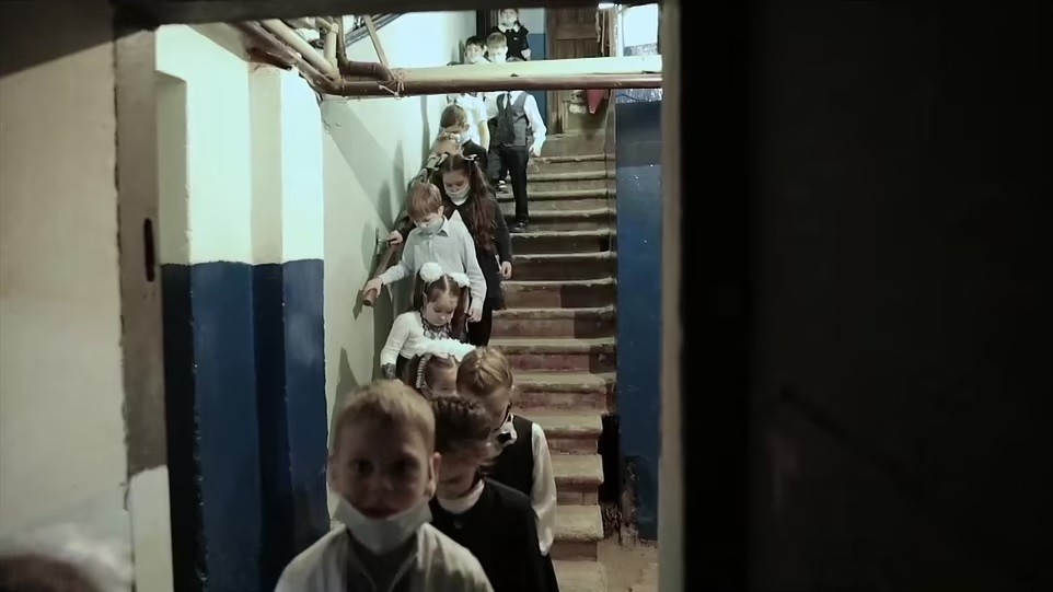 Os pequenos em fila, descendo para os abrigos (Foto: Reprodução/ BBC)