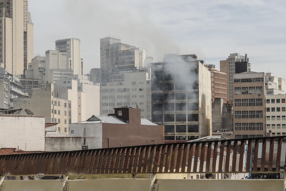 Fumaça sai de prédio atingido por incêndio na região da 25 de Março, no Centro de São Paulo, nesta terça-feira (12) — Foto: Celso Tavares/g1