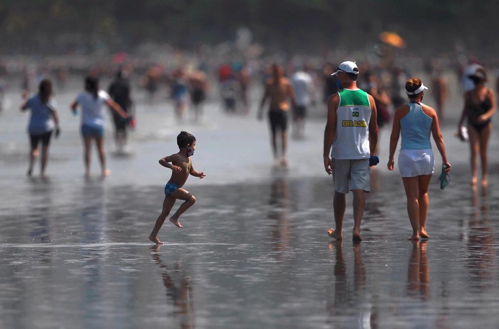 Criança brinca na faixa de areia da praia de Santos, SP, neste sábado (5) — Foto: Matheus Tagé/Jornal A Tribuna