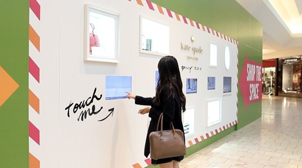Consumidora interage com a parede de uma loja (Foto: Divulgação)