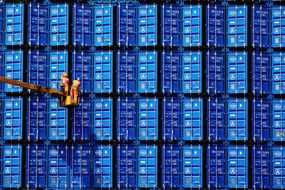 FuncionÃ¡rios inspecionam containers em uma fÃ¡brica em Jinzhou, na provÃ­ncia de Liaoning, na China.  â€” Foto: China Daily via Reuters